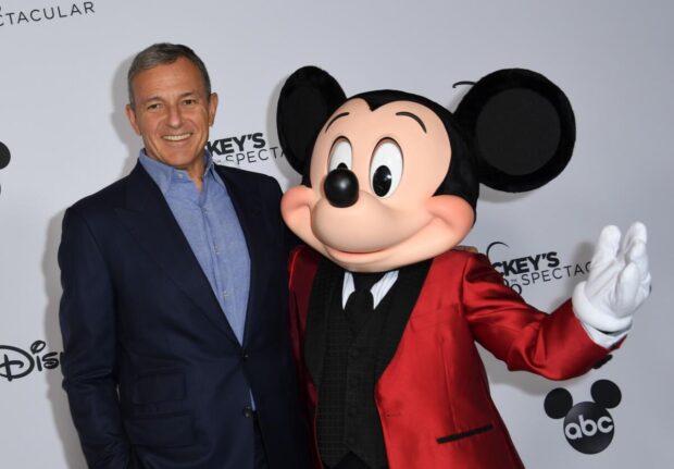 CEO da Disney Bob Iger ao lado do icônico Mickey Mouse: fim da agenda "woke" provoca polêmicas.