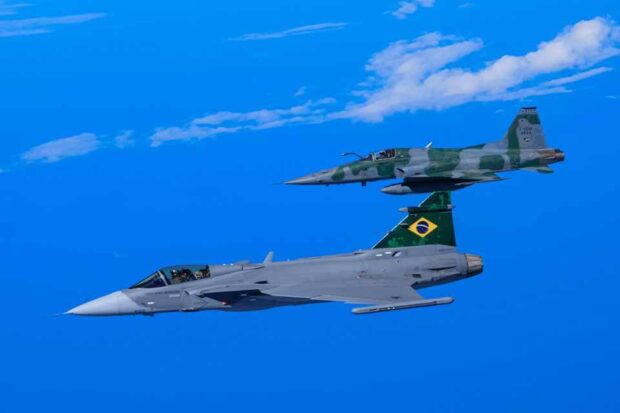 Gripen E da FAB voa ao lado de um F-5E Tiger.